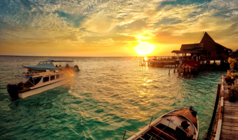 Foto matahari terbenam dari dermaga hotel resor pantai di Maratua, Indonesia. Shutterstock/Lemonade Serenade