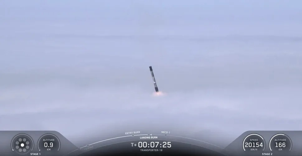 The Falcon 9 first stage that launched the Transporter-18 mission pierces the clouds above California's Vandenberg Space Force Base during its return to Earth on Oct. 1, 2026. (Image credit: SpaceX)