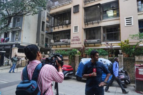 News media personnel stand outside the building where relatives of Smit Machchhar, an Indian pilot for Flydubai, previously lived in Mumbai, India, Thursday, Oct. 1, 2026. (AP Photo/Rafiq Maqbool)