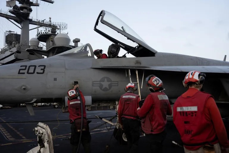 US Navy sailors tend to a fighter jet on the flight deck of the USS George Washington in the Arabian Sea [File: Ed Ou/Reuters]