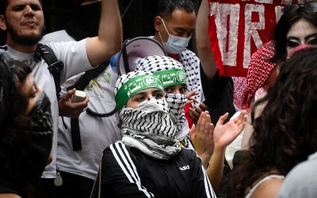 Anti-Zionist protesters wearing Hamas headbands outside Baruch College, in New York City, June 5, 2024. (Luke Tress/Times of Israel)