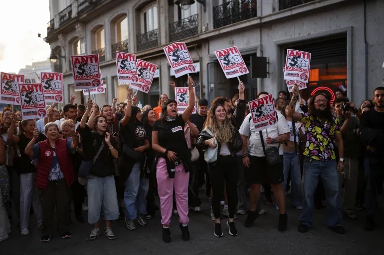 Demonstrators hold placards reading 'Antifascists' during a protest in Madrid against the housing crisis [Alejandro Martinez Velez/Reuters]