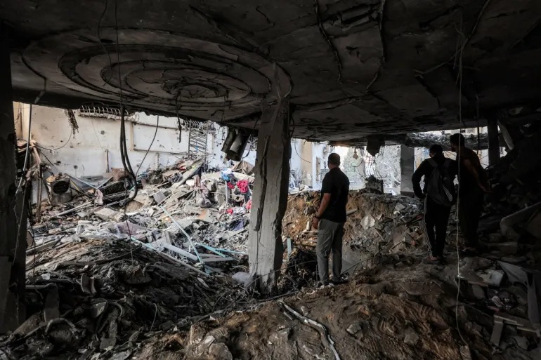 People inspect the damage after an Israeli attack on a residential apartment in the Remal neighbourhood of Gaza City [Omar al-Qattaa/AFP]
