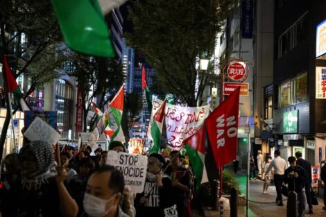 Participants carrying Palestinian flags and protest signs move through Shibuya during a pro-Palestinian march in Tokyo, Japan, on October 7, 2026. Credit: Associated Press