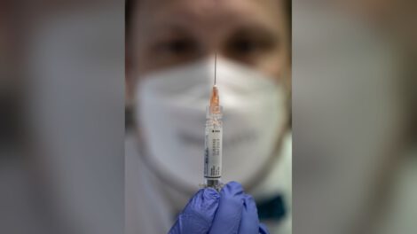 A medical worker holds a flu shot in Bad Honnef, Germany, in 2022. (Ulrich Baumgarten/Getty Images)