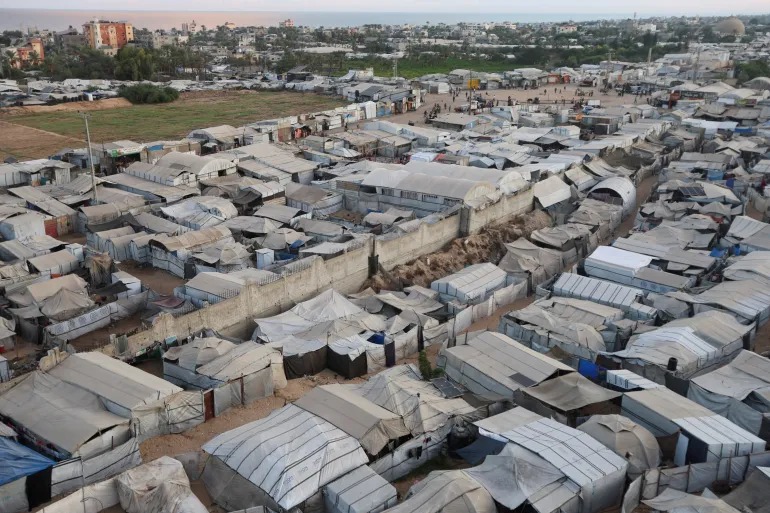 A tent camp shelters displaced Palestinians in al-Mawasi on the coast of the southern Gaza Strip on October 7, 2026 [Ramadan Abed/Reuters]