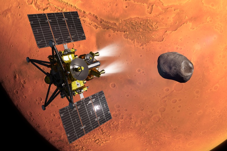An artist’s concept of JAXA’s MMX spacecraft during its Mars’ orbit insertion. The Martian moon Phobos, which MMX will explore and sample, is in the background. JAXA
