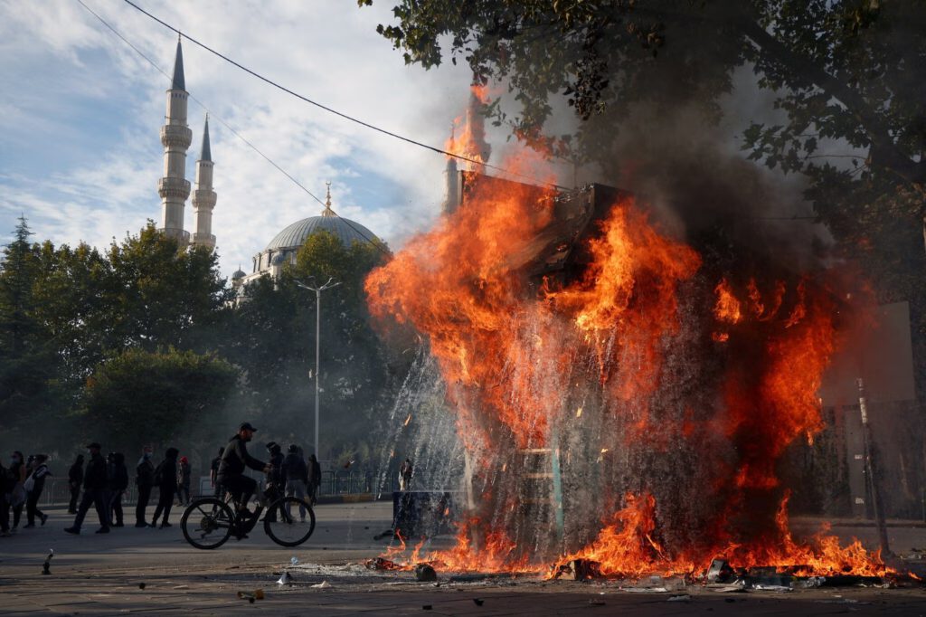 Flames engulfing a kiosk during clashes between police and demonstrators in Tirana on Thursday.Credit...Florion Goga/Reuters