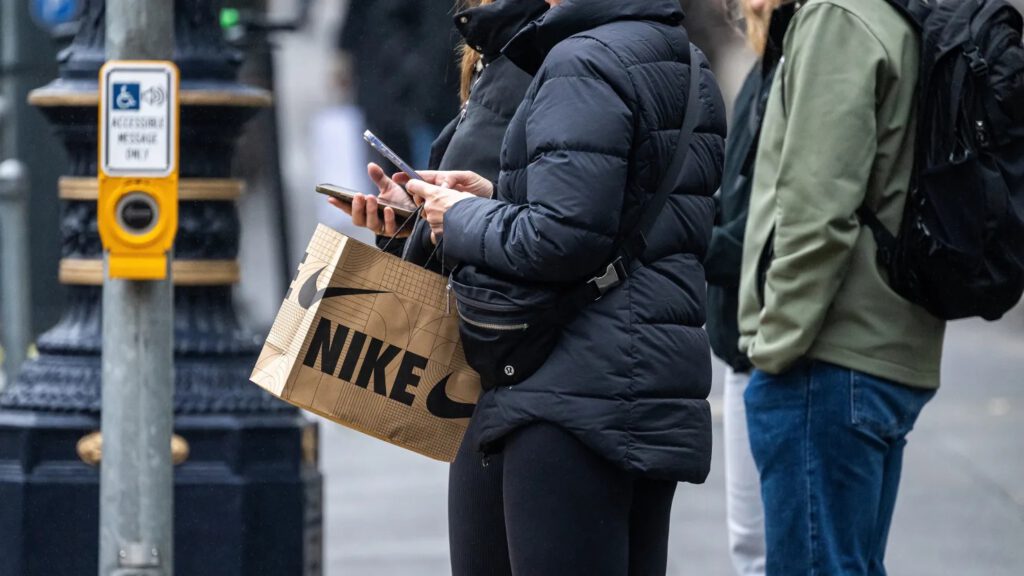 A shopper carries a Nike bag in San Francisco, Dec. 17, 2025. David Paul Morris | Bloomberg | Getty Images